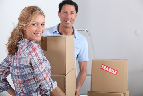 Removalists carrying boxes through a London home staircase